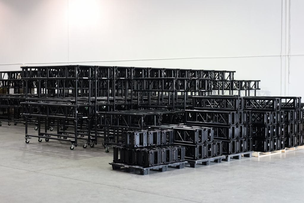 Black Tyler GT truss and Black truss from Tyler Truss stacked on the floor of a warehouse.